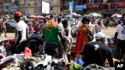 FILE - Pedestrians shop for clothes at Mokolo Market in Yaounde, Cameroon, Oct. 11, 2018. 