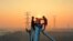 Employees work on a high voltage transmission tower in Yichun, in China's central Jiangxi province, Sept. 28, 2021.