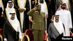 FILE - Qatar's Emir Sheikh Hamad bin Khalifa al-Thani (R) stands next to his son Crown Prince Sheikh Tamim bin Hamad al-Thani before the Emir Cup final match between Al-Sadd and Al-Rayyan at Khalifa stadium in Doha, May 18, 2013. 