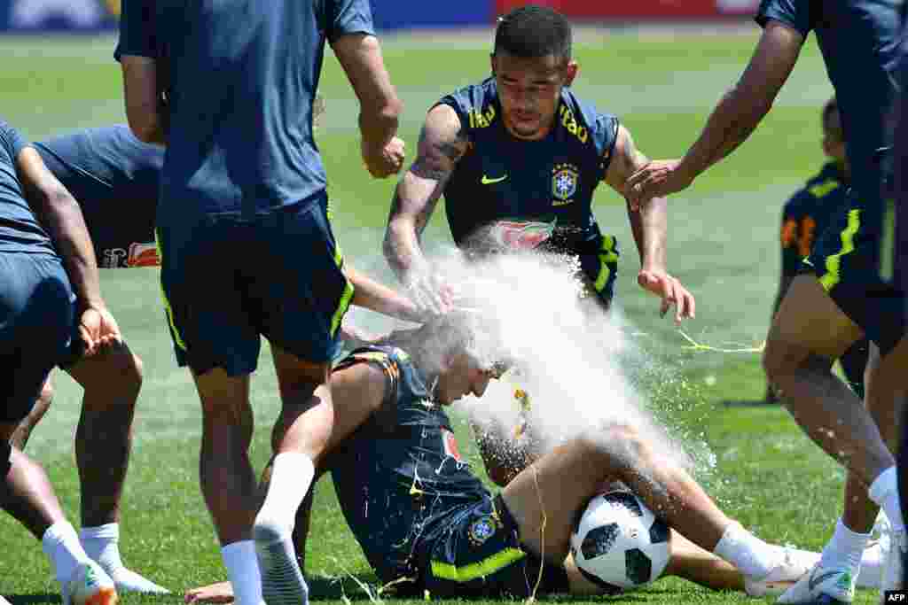 Mchezaji wa Brazil&#39;s Neymar (haonekani) na&nbsp; Gabriel Jesus (katikati) wakivunja yai juu ya kichwa cha mchezaji wa timu yao Philippe Coutinho wakisheherekea siku ya kuzaliwa kwake wakati wa maandalizi ya michuano ya Kombe la Dunia Juni 12, 2018 huko Russia.