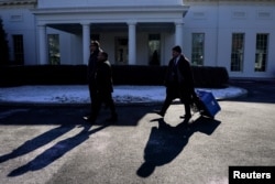 Seorang pekerja membawa peralatan di Gedung Putih, pada hari pelantikan masa jabatan kedua Donald Trump sebagai presiden di Washington, Amerika Serikat, 20 Januari 2025. (Nathan Howard/REUTERS)