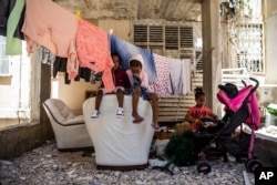 Djeca, eritrejski tražitelji azila, prvi put nakon nekoliko dana sjede ispred svog stana u Ashdodu u Izraelu prije nego što su u utorak, 18. maja, širom grada i drugih područja zazvonile sirene upozorenja na rakete iz pojasa Gaze, 18. maj.