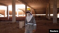 FILE - Former slave Paulo Franca works at the construction site of the Arena Pantanal stadium in Cuiaba, Brazil, February 7, 2012.