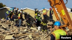 Rescuers work to rescue construction workers trapped under a building that collapsed in George, South Africa May 7, 2024.