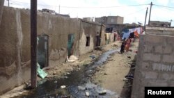 Children walk down an alleyway where sewage runs freely in Pikine, Senegal, Oct. 16, 2015. 