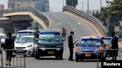 A police officer controls a car at a roadblock to restrict inter-city movement during partial lockdown to slow the spread of the coronavirus disease (COVID-19), in Circle neighborhood of Accra, Ghana, March 31, 2020.