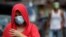 A woman wearing a protective mask walks outside a village that was placed under lockdown due to the number of COVID-19 cases among residents in Manila, Philippines, on March 11, 2021. 