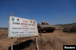 Sebuah pengangkut personel lapis baja (APC) militer Israel bermanuver di dekat sebuah tanda di Dataran Tinggi Golan yang dikuasai Israel di dekat perbatasan Israel-Suriah pada 3 Agustus 2020. (Foto: REUTERS/Ronen Zvulun)