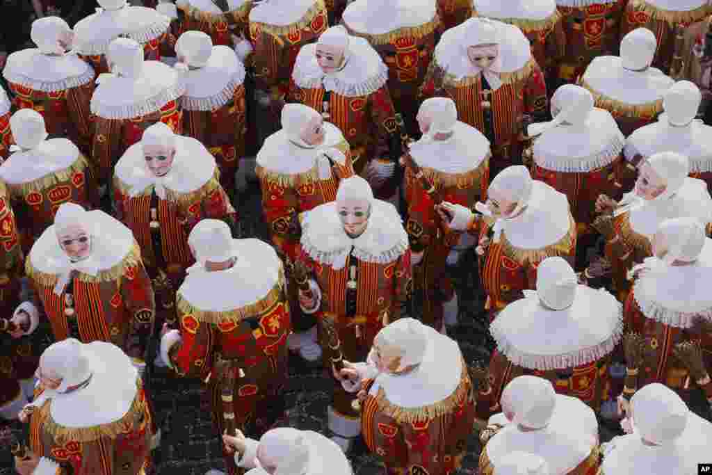 The Gilles of Binche wear their traditional wax masks attend Carnival celebrations in Binche, Belgium.