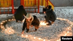 Supporters of Russian opposition politician Alexei Navalny, who was recently jailed for parole violations, arrange candles in the shape of a heart in a residential courtyard during a gathering on Valentine's Day in Omsk, Russia, Feb. 14, 2021.