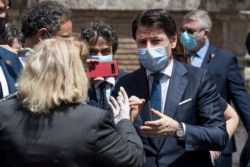 Italian Premier Giuseppe Conte talks to a woman after attending a session at the Senate in Rome, May 20, 2020.