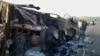 People look at a vehicle that was torched by gunmen after they killed passengers at a highway in Musakhail, a district in Baluchistan province in southwestern Pakistan, Aug. 26, 2024. 