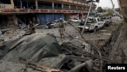 FILE - An Afghan policeman inspects the site of a blast near the Indian consulate in Jalalabad, Afghanistan, March 2, 2016. Security forces killed the suicide bombers who targeted the building.