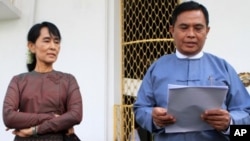 Burma's Labor and Social Welfare Minister Aung Kyi, right, reads a statement to the media after meeting with Aung San Suu Kyi, left, at Seinlekhanthar government guest house in Yangon, July 25, 2011