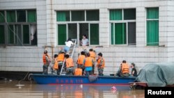 Des secouristes aident à l'évacuation d'une maison à Xinshao, dans la province de Hunan, Chine, le 2 juillet 2017.