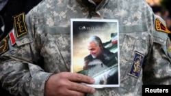 A demonstrator holds a picture of Qassem Soleimani, the assassinated head of the elite Quds Force, in Tehran, Iran, Jan. 3, 2020.