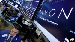 FILE - In this March 15, 2016 photo, specialist Ronnie Howard works under the Avon logo on the floor of the New York Stock Exchange.