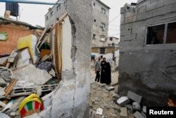 Warga Palestina bereaksi di lokasi serangan Israel terhadap rumah-rumah, di tengah konflik yang sedang berlangsung antara Israel dan kelompok Islam Palestina Hamas, di Khan Younis di selatan Jalur Gaza, 29 Oktober 2023. (Foto: REUTERS)