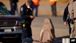 Law enforcement officers sort evidence and debris at the scene of a deadly crash in Holtville, Calif., March 2, 2021. 