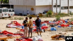 Des migrants marchent à l'extérieur du centre de détention utilisé par le gouvernement libyen à Tajoura, dans la banlieue sud de Tripoli, le 3 juillet 2019.