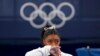 Simone Biles of the United States watches gymnasts perform at the 2020 Summer Olympics, in Tokyo. Biles says she wasn't in right "headspace" to compete and withdrew from the gymnastics team final. 