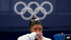 Simone Biles of the United States watches gymnasts perform at the 2020 Summer Olympics, in Tokyo. Biles says she wasn't in right "headspace" to compete and withdrew from the gymnastics team final. 