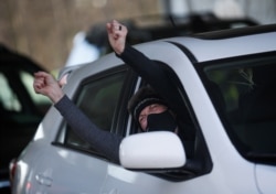 FILE - A woman cheers after receiving the first dose of the Moderna COVID-19 vaccine at a free drive-through coronavirus vaccine clinic, in Sequim, Washington, Jan. 23, 2021.