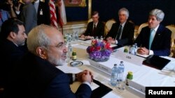 Menteri Luar Negeri Iran Mohammad Javad Zarif (kiri) bertemu dengan Menteri Luar Negeri AS (kanan) dalam perundingan antara enam menteri-menteri luar negeri bernegosiasi dengan Teheran tentang program nuklir di Vienna, 13 Juli 2014. (REUTERS/Jim Bourg)