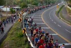 FILE - Central American migrants, part of the caravan hoping to reach the U.S. border, walk in Frontera Hidalgo, Mexico, April 12, 2019.