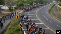 FILE - Central American migrants, part of the caravan hoping to reach the U.S. border, walk in Frontera Hidalgo, Mexico, April 12, 2019.