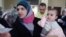 Hassana Abu Firasl, left, a Syrian woman who fled from the Syrian town of Qusair near Homs, is seen with her family at the Lebanese-Syrian border village of Qaa, eastern Lebanon,  Monday, March 5, 2012. 