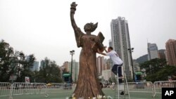 FILE - A worker from the Hong Kong Alliance in Support of Patriotic Democratic Movements in China prepares the Goddess of Democracy statue at Hong Kong's Victoria Park on June 4, 2010. (AP Photo/Kin Cheung, File)