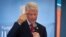 Former president Bill Clinton gestures while wearing a bracelet given to him by Kenyan students, as he and and his daughter Chelsea Clinton talk about their foundation's "No Ceilings" project at Farasi Lane Primary School in Nairobi, Kenya, May 1, 2015.