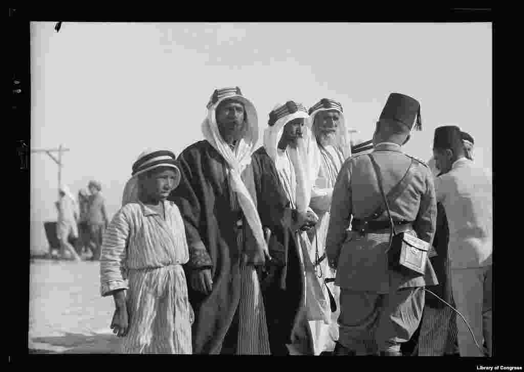 Bedouins and British officers celebrating the end of the 1930 locust campaign at Beersheva. The first in a succession of swarms appeared in the Jordan valley at the end of October 1929. The extensive use of poison baits in the Beersheba area led to concerns that arsenic was being washed out by winter rains and contaminating cisterns used to collect rain water. 