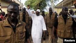 Incumbent President Alpha Conde, leader of Rassemblement du Peuple de Guinea (RPG), waves as he leaves the polling station during a presidential election in Conakry, Guinea, Oct. 11, 2015. 