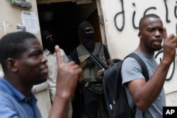 The bodyguards of current and former senators being questioned by prosecutors wait in the doorway outside the court, behind men who support the politicians in Port-au-Prince, Haiti, July 12, 2021.