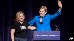 Elizabeth Warren, United States senator from Massachusetts and one of the many Democrats running for president in 2020, enters the stage with San Juan Mayor Carmen Yulin Cruz Soto at the Alejandro Tapia y Rivera Theater, in San Juan, Puerto Rico, Jan. 22, 2019.