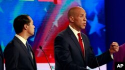 Los aspirantes demócratas a la presidencia Julián Castro (izquierda) y Cory Booker durante el debate demócrata organizado por NBC News en el Centro de Artes Escénicas Adrienne Arsht el miércoles 26 de junio de 2019 en Miami. (AP Foto/Wilfredo Lee)