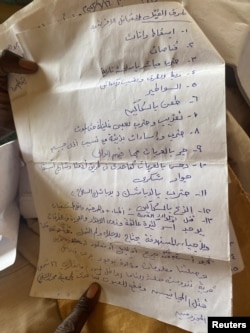 FILE - Notes taken by Gamar Khater, a Masalit elder in El Geneina, of the atrocities he says he witnessed during the Arab assaults in the city, in Adre, Chad July 22, 2023.