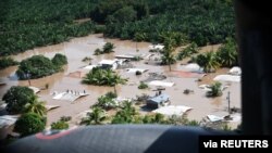 Hondureños parados en tejados rodeados por las inundaciones dejadas por el huracán Eta en San Pedro Sula, Honduras, el 7 de noviembre de 2020. 