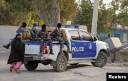 A Somali police vehicle drives to the scene of an explosion at a restaurant often visited by police officers near Mogadishu, Somalia, Oct. 17, 2024.