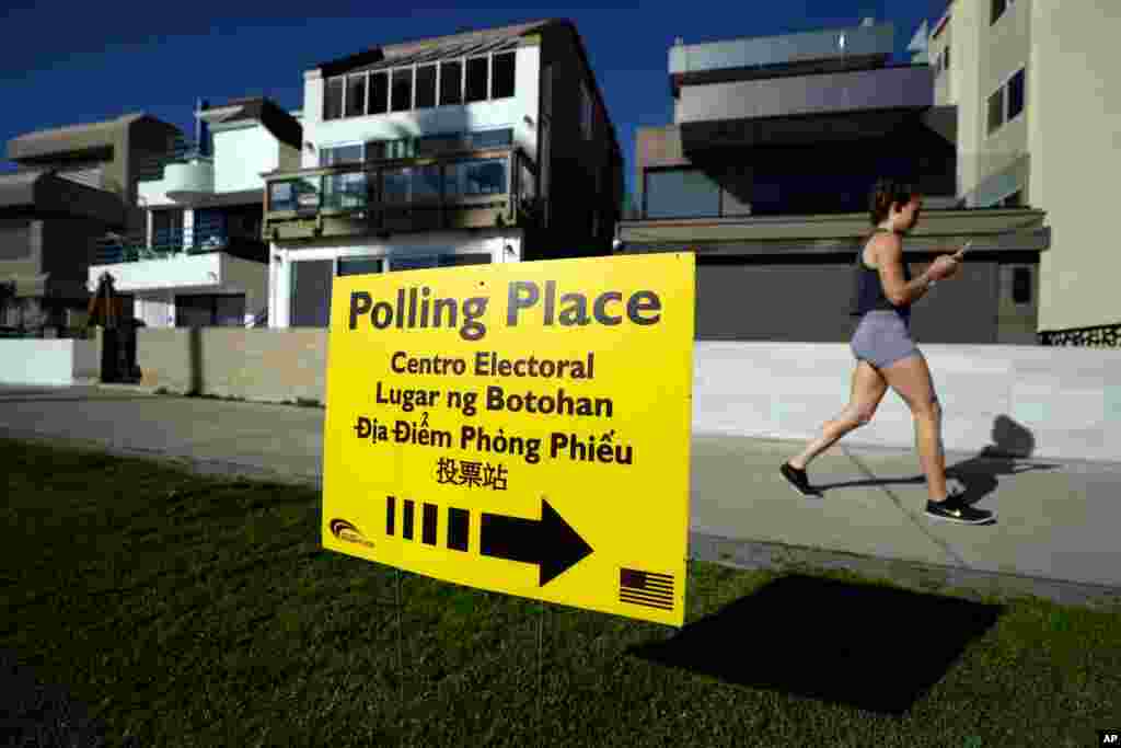 A woman runs on a path by a polling place during primary elections, March 3, 2020, in San Diego. 