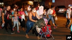 Para migran berjalan di sepanjang jalan raya dengan harapan mencapai Amerika Serikat, di San Pedro Sula, Honduras, Rabu, 30 September 2020. (Foto: AP)