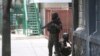 FILE - Police take cover during an anti-gang operation next to the National Palace in Port-au-Prince, Haiti, Monday, April 8, 2024.