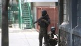 FILE—Police take cover during an anti-gang operation next to the National Palace in Port-au-Prince, Haiti, April 8, 2024. 