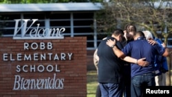 Warga berkumpul di Robb Elementary School, lokasi penembakan massal di Uvalde, Texas, AS, 25 Mei 2022. (Foto: REUTERS/Nuri Vallbona)