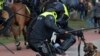 Dutch riot police kick a man during a demonstration to protest government policies including the curfew, lockdown and coronavirus related restrictions in The Hague, Netherlands.