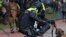 Dutch riot police kick a man during a demonstration to protest government policies including the curfew, lockdown and coronavirus related restrictions in The Hague, Netherlands.