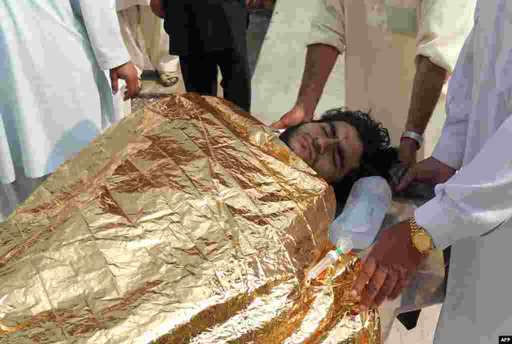 Men carry an injured bombing victim into a hospital after a Taliban attack on a rivial militia, Kohat, Pakistan, Oct. 3, 2013.