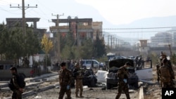 FILE - Afghan security personnel gather at the site of car bomb in Kabul, Afghanistan, Nov. 13, 2019. A car bomb detonated in the Afghan capital of Kabul during the morning commute, killing several people, officials said. 